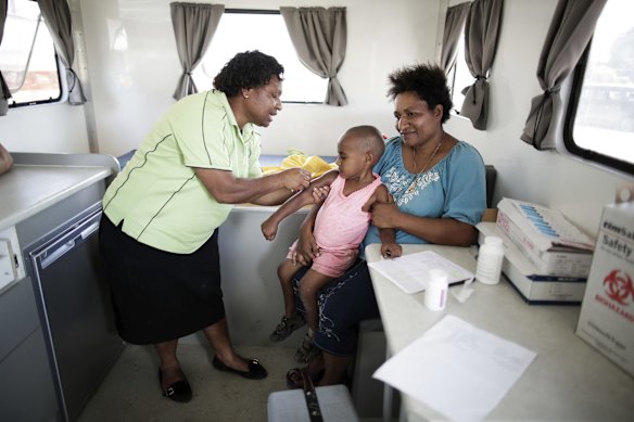 Wendy with her 3-year-old daughter Beverly who is receiving her rubella vaccination at a mobile clinic operated by Susu Mamas at the side of the Highlands Highway on the outskirts of the Western Highlands town of Mount Hagen. Susu Mamas provides maternal and child health services to the doorstep of remote communities operates in 6 provinces and the National Capital District. 