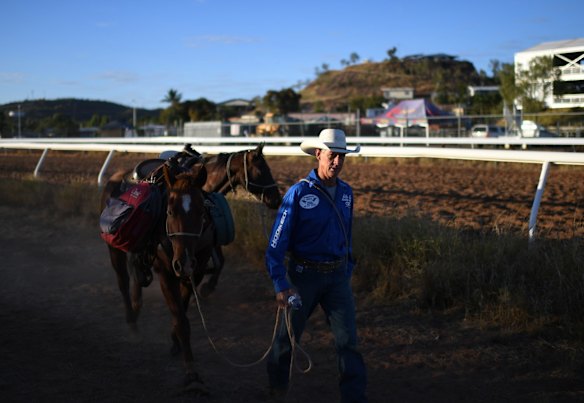 Rodeo competitor Warwick Hale walks his horses to the arena before the start of competition at the Mount Isa Mines Rodeo.