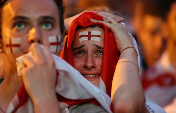 England soccer fans react after Croatia scored their side's second goal as they watch a live broadcast on a big screen of the semifinal match between Croatia and England at the 2018 soccer World Cup, in Flat Iron Square, south London.
