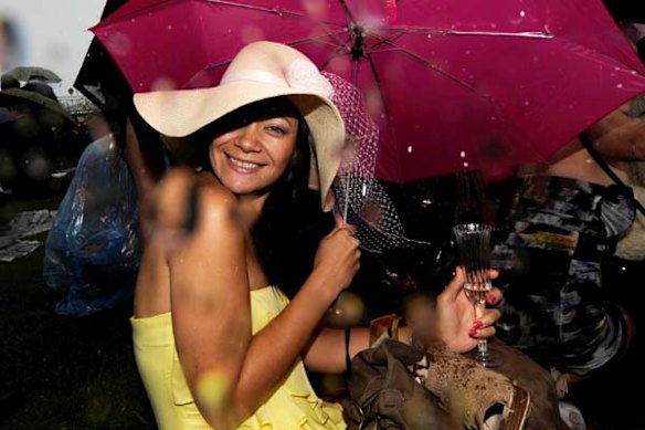 Cup fans on the lawns duck for cover from the rain.