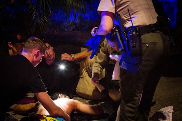 Police and medics examine an unidentified man who sustained injuries late May 23, 2014 during a drive-by shooting  in Isla Vista, California.