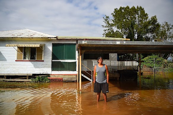 Brandan Harrington, a Rural Fire Service volunteer stands amongst the water surrounding his home on the banks of the Wilson River at Wyrallah, NSW. 