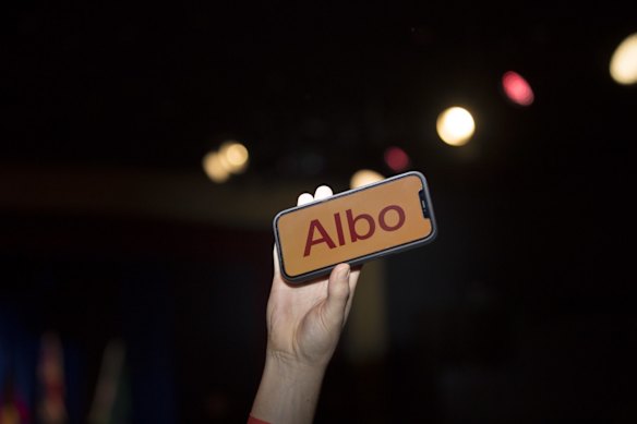 An attendee holds a phone reading "Albo" during the Labor Party election night event in Sydney, Australia. Australia's Labor Party is set to take power for the first time since 2013, as voters booted out Prime Minister Scott Morrison's conservative government in a shift likely to bring greater action on climate change and a national body to fight corruption.