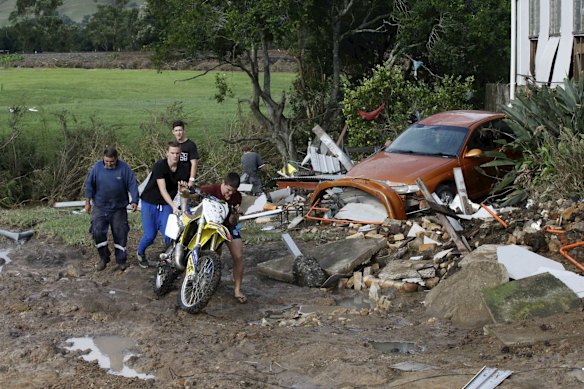 Local residents retrieve a motorbike which was washed away by flood
waters in Dungog, NSW. 