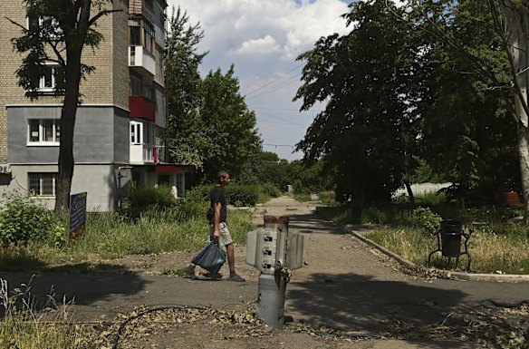 A man walks past an unexploded missile in the street of Lysychansk, a city under constant artillery fire from the Russian military and without water and power. Lysychansk, Ukraine. 
