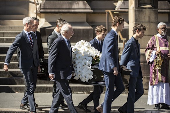 The casket is carried out as family and friends gather after the state funeral of fashion designer Carla Zampatti AC.