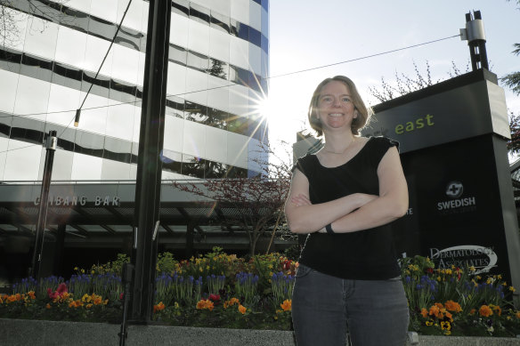 Jennifer Haller, the first patient to receive a vaccine shot, poses before going into the Kaiser Permanente Washington Health Research Institute to get her second dose of the vaccine, in Seattle. 