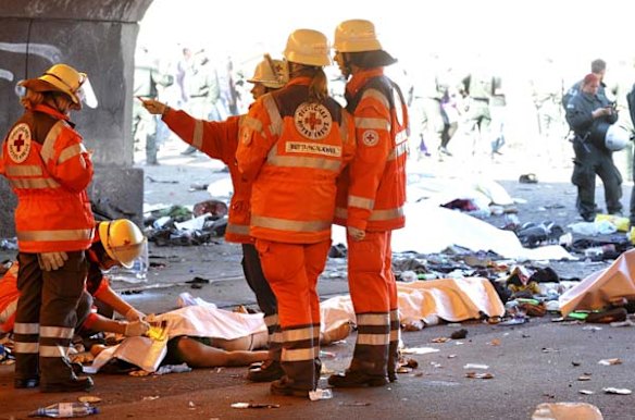 Rescue workers stand beside casualties after a stampede in a tunnel during the Love Parade festival in Duisburg, western Germany.