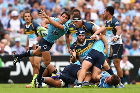 Nick Phipps of the Waratahs passes 