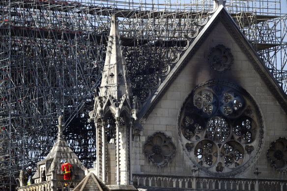 A firefighter makes his way on a balcony of Notre-Dame Cathedral.