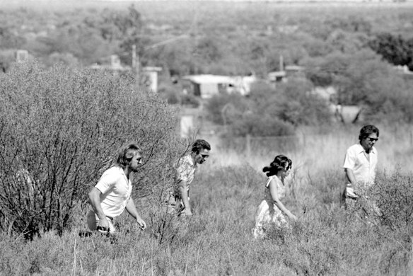 Lindy Chamberlain and Michael Chamberlain walk through the scrub at Ayers Rock as the inquest into their daughter, Azaria, continues at the site of her disappearance, December 1981.