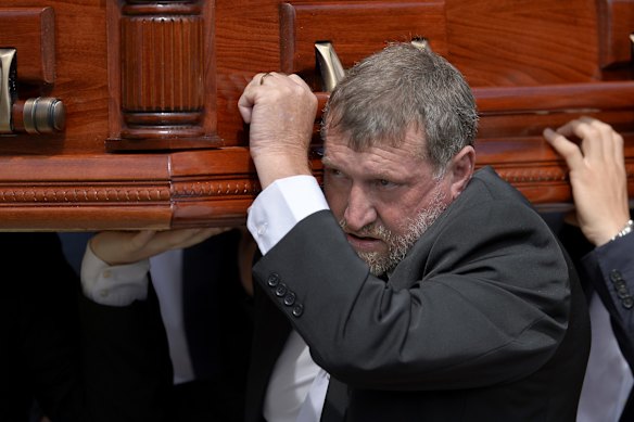 Greg Hughes carries his son's casket.