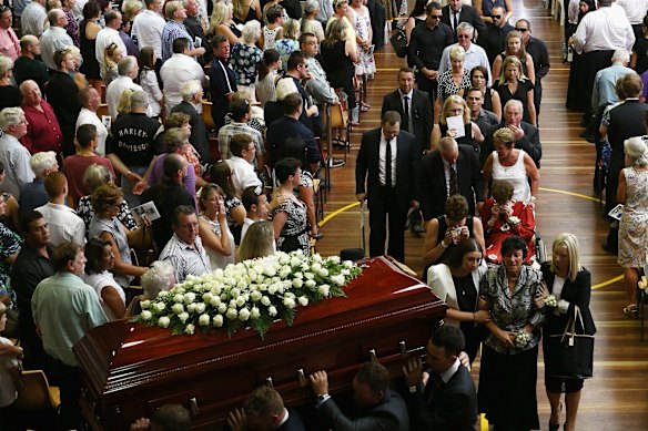 Virginia Hughes, mother of Phillip Hughes is comforted as The coffin of Phillip Hughes is carried down the aisle.