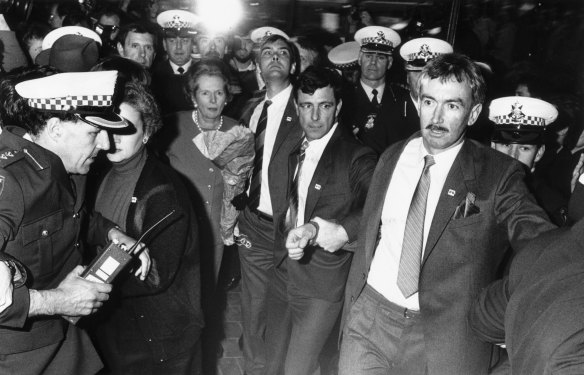 Police and security guards escort Margaret Thatcher through the 
Bourke Street Mall on August 3, 1988.  
