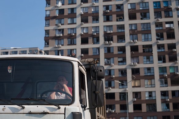 A truck driver waits for rubble to be loaded on his vehicle in Kyiv.