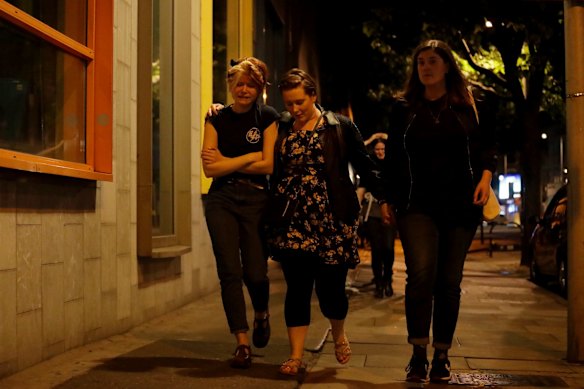 People walk away about 10 minutes after midnight from inside a police cordon after an attack in London. 
