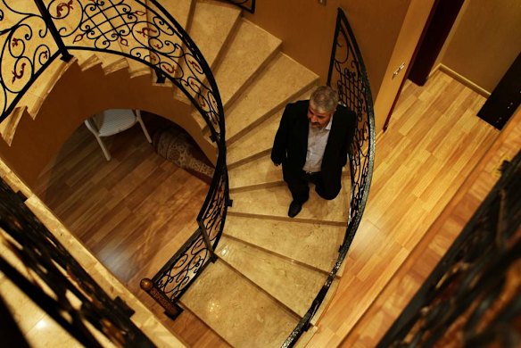 Khalid Mishal walks down a staircase at a house in Doha, Qatar.