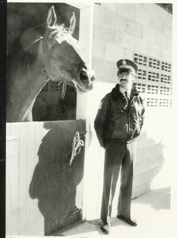 A policeman guarding a ring-in horse.