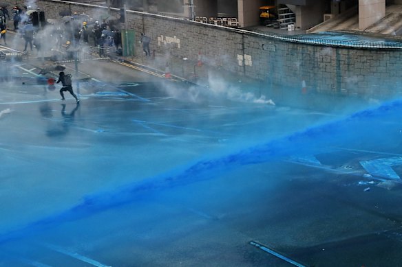 Police fire blue-coloured water from water cannons at protesters in central Hong Kong.