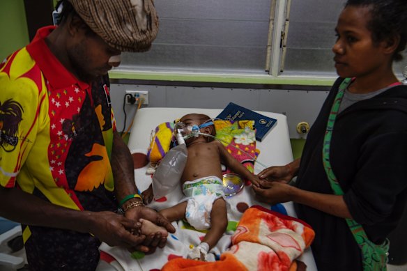 Nine-month-old Valentino Jason with his parents in the tuberculosis and HIV ward at Port Moresby General Hospital.