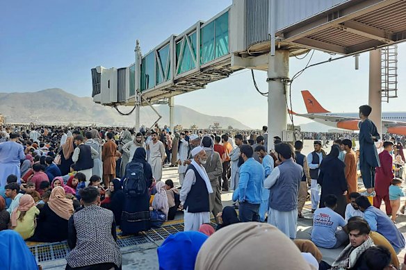 Afghans crowd at the tarmac of the Kabul airport to flee the country as the Taliban were in control of Afghanistan after President Ashraf Ghani fled the country and conceded the insurgents had won the 20-year war. 

