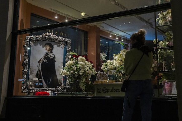 A woman looks at a portrait of Queen Elizabeth II, on display in a boutique, in London, Saturday, Sept. 10, 2022.  