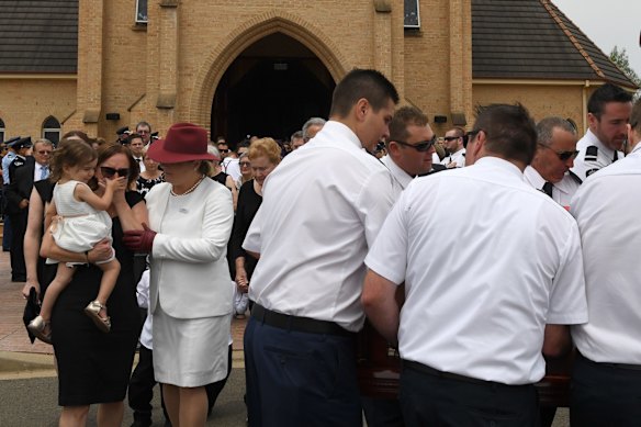 Melissa and Charlotte O'Dwyer, the wife and young daughter of Rural Fire Service volunteer Andrew O'Dwyer, farewell their husband and father during the funeral for NSW RFS volunteer Andrew ODwyer.