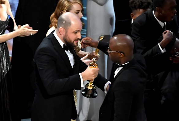 <i>La La Land</i> producer Jordan Horowitz, left, hands over the best picture award to <i>Moonlight</i> writer-director Barry Jenkins after <i>La La Land</i> was incorrectly named as the winner.