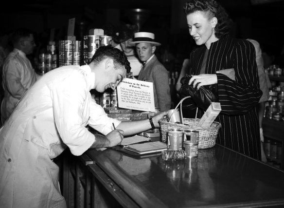 Purchasing groceries with a basket at David Jones in Sydney on February 9, 1942. The sign reads”Restriction on delivery of parcels”.