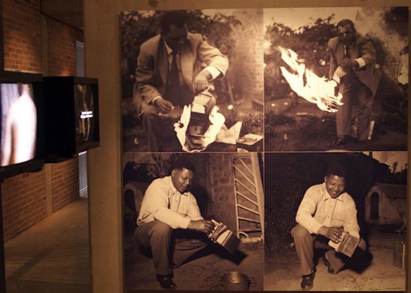 Photographs of former African National Congress leaders Walter Sisulu, and Nelson Mandela, burn  pass books in the early 1960's, which were compulsory for black South Africans to carry, in a photo exhibit at the Apartheid Museum in Johannesburg.