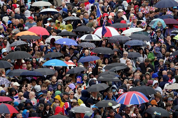 Crowds in Trafalgar Square watch the coronation on large screens.