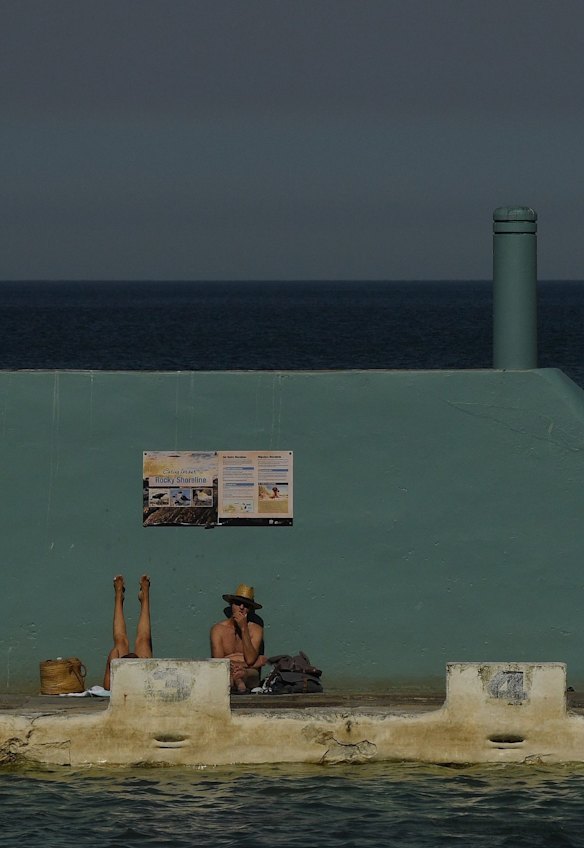 People dry off after a swim, near the ocean baths at Newcastle, as temperatures rise during lockdown.