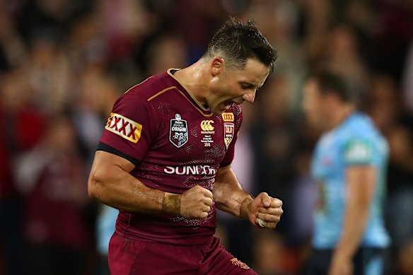 Cooper Cronk of the Maroons celebrates the try scored by Valentine Holmes.