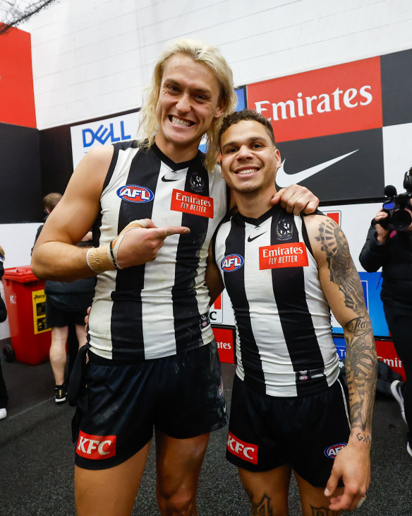 Skipper Darcy Moore celebrating with small forward Bobby Hill in the Collingwood rooms after the win over Melbourne. His right wrist and thumb were strapped for the game.
