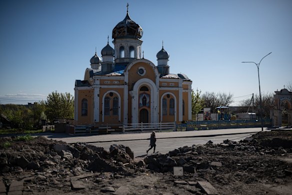 A woman walks by the damaged St Godmothers Cover Church in Malyn.