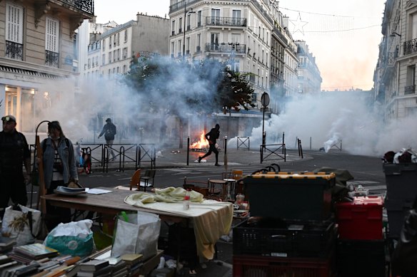 A protester runs through tear gas at a flea market in Paris.