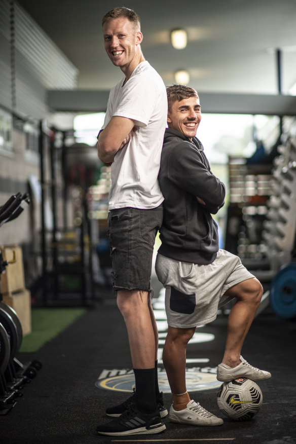 Josh Nisbet, who stands 160 centimetres tall, with Central Coast Mariners teammate Adam Pearce, who nudges two metres.