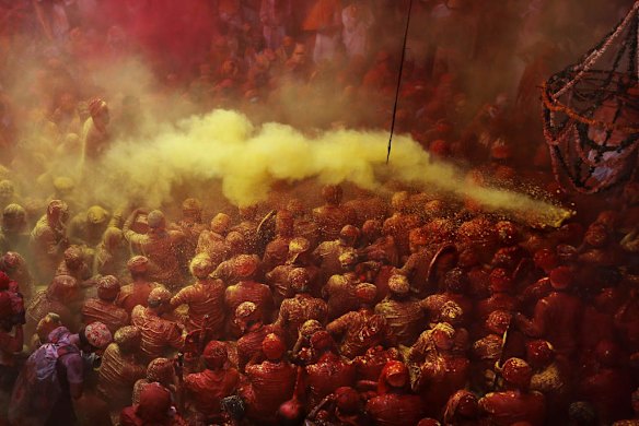 Hindu men from the village of Nandgaon are covered in coloured powder.