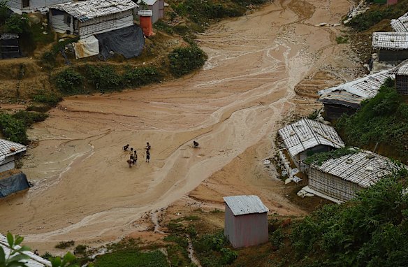 Rohingya children play in the mud in Kutupalong Camp during a heavy downpour. 