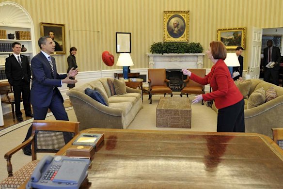 Julia Gillard takes AFL footy the Oval Office, handpassing to US President Barack Obama in 2011.