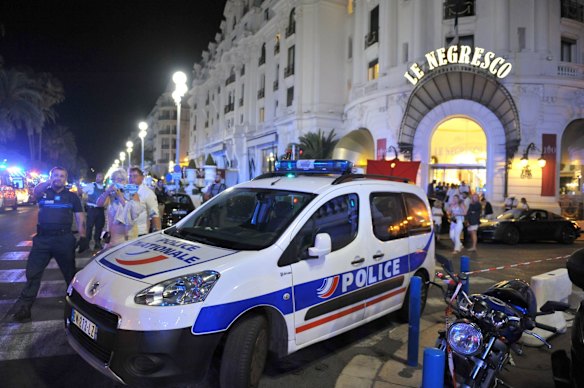 A Police car is parked near the scene of an attack after a truck drove on to the sidewalk and plowed through a crowd of revelers who'd gathered to watch the fireworks.