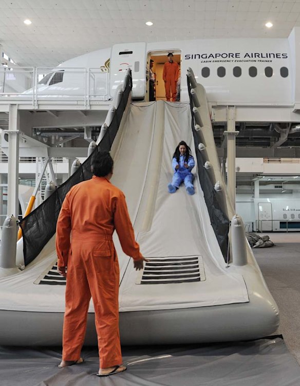 Singapore Airlines cabin crew perform a land evacuation exercise from a mock-up plane.