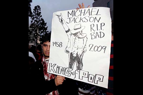 An unidentified man holds up a Michael Jackson poster outside the UCLA Medical Center, where entertainer Michael Jackson was taken, in Los Angeles.