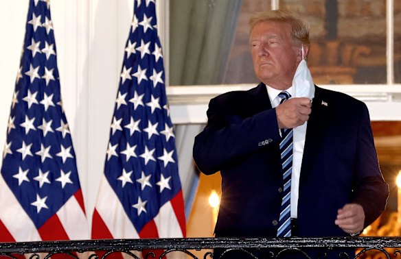 President Donald Trump removes his mask after returning to the White House from Walter Reed National Military Medical Centre on October 5, 2020. Trump spent three days hospitalised for coronavirus.