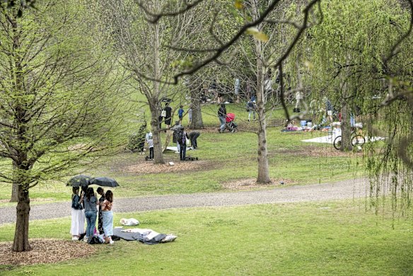 Picnics are packed up as the rain begins to fall at Centennial Park, as some restrictions ease.
