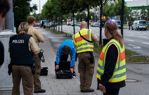 Police officers search a man outside the shopping centre.