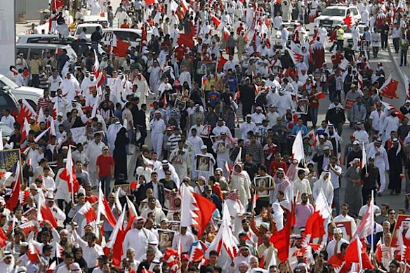 Thousands of protesters with Bahraini flags take part in a pro-government march in the capital Manama.