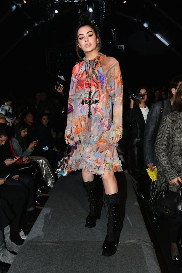Charli XCX attends the Moschino show wearing a boho seventies inspired floral number.