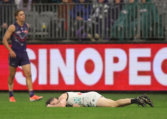 Game over: Darcy Byrne-Jones of the Power on the turf after his run-in with Alex Pearce.
