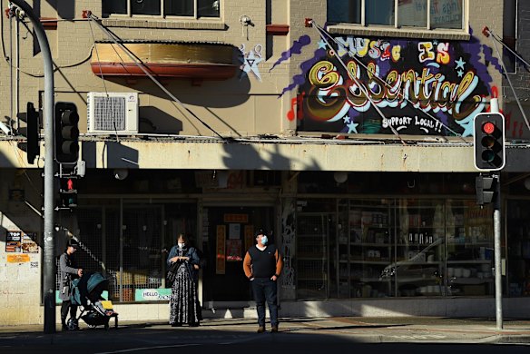 People wait at traffic lights at the intersection of Marrickville and Illawarra roads in Marrickville during the COVID-19 lockdown.